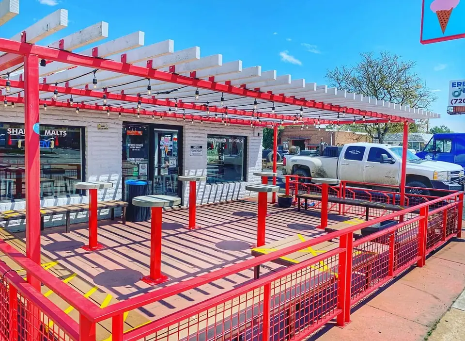 Red steel pergola and patio railing at a restaurant