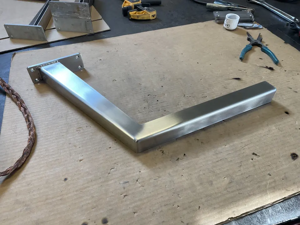 Polished stainless steel bracket on a workbench